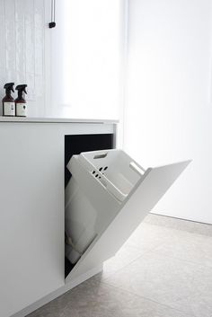 an open trash can in the corner of a kitchen