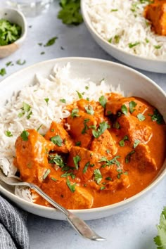 two bowls filled with chicken tikka and rice on top of a white tablecloth