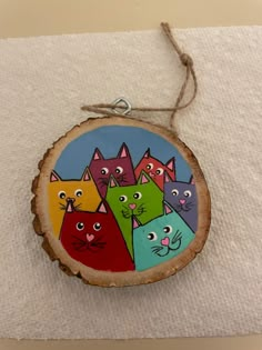 a wooden ornament with cats painted on it