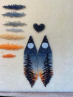 two fish made out of seed beads sitting next to each other