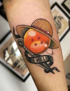 a tattoo on the leg of a person with scissors and an orange ball in it