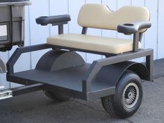 a golf cart with two seats on the front and back wheels is parked in front of a building