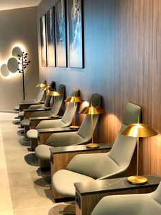 a row of chairs sitting next to each other in front of a wall mounted lamp