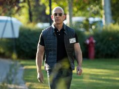 a man walking across a lush green park