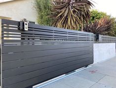 a metal fence with vertical slats on the sides and an electrical box attached to it