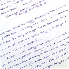 a close up of writing on a piece of paper with cursive writing in blue ink