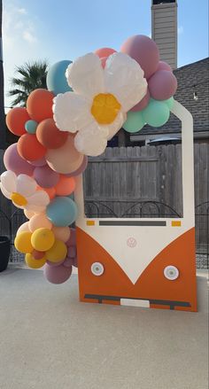 an orange and white bus with balloons attached to it