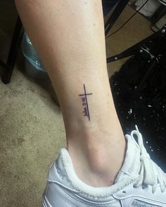 a woman's foot with a small cross tattoo on the left side of her ankle