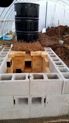 a large black barrel sitting on top of a cement block