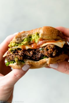 a hand holding a sandwich with meat, lettuce and tomato on it in front of the camera text reads seriously the best black bean burgers