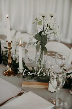 the table is set with white flowers and candles