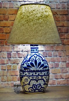 a blue and white vase sitting on top of a wooden table next to a lamp