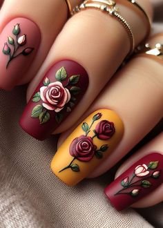 🌟 Roses aren’t just for bouquets! These golden-hued nails feature delicate crimson petals, as if a garden fairy brushed her magic across your fingertips. Channel your inner enchantress with this elegant nail art. 🌹🧚‍♀️ Beauty And The Beast Rose Nails, Red Nails With Roses, Roses Nails, Beauty And The Beast Nails Designs, Red Rose Nail Design, Red Roses Nail Art, Blooming Gel Rose Nail Art, Beauty And The Beast Nails