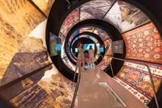 two people are walking down an escalator in a museum