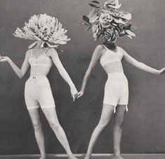 two women with flowers on their heads holding hands