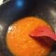 an orange being cooked in a frying pan