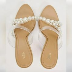 Heeled Vinyl Sandals With Faux Pearls. Color: Beige White Open Toe Jelly Sandals For Party, Trendy Spring Wedding Sandals, White Jelly Sandals With Round Toe For Party, White Synthetic Jelly Sandals For Party, Flat Heel Synthetic Sandals For Wedding, Trendy Summer Wedding Sandals, Trendy Wedding Sandals For Summer, White Closed Toe Synthetic Jelly Sandals, White Closed Toe Jelly Sandals