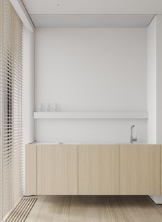 an empty bathroom with wooden flooring and white walls, along with two sinks in the middle