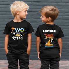 two young boys wearing matching black t - shirts