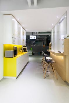 a kitchen with yellow counter tops and stools in front of the counter top area