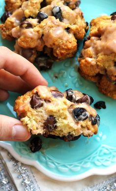 someone is holding an oatmeal cookie with raisins and chocolate chips