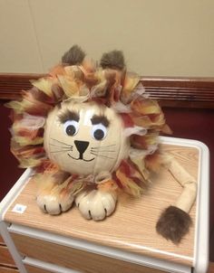 a stuffed lion sitting on top of a wooden table