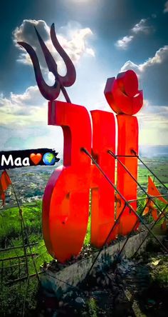 a large red sign sitting on top of a lush green field