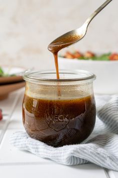 a spoon full of brown sauce sitting on top of a table