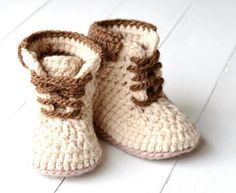 a pair of crocheted baby booties sitting on top of a white wooden floor