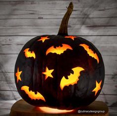 a carved pumpkin with bats and stars on it