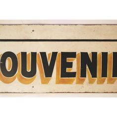 an old sign with the word ouvenir written in black and yellow letters on it