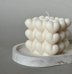 a white candle sitting on top of a marble plate