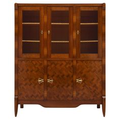 a wooden cabinet with glass doors and gold handles