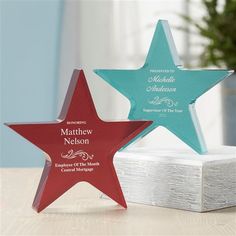 three star shaped award plaques on top of a table