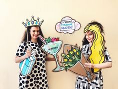 two women dressed in costumes holding up signs