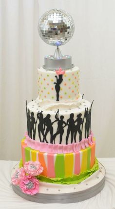 a multi layer cake decorated with disco balls and dancing silhouettes on the top tier