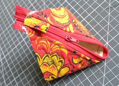 a red and yellow flowered pouch sitting on top of a table