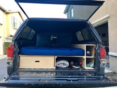 the back end of a truck with an open bed and storage drawers in it's trunk