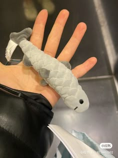 a hand that has a stuffed animal in it