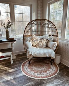 a living room with a swing chair, rug and windows