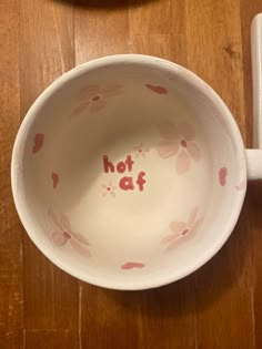 a bowl with the word hot at written in red on it sitting on a wooden table