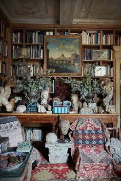 a living room filled with lots of furniture and bookshelves next to a painting