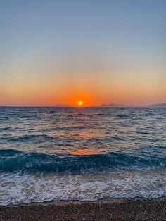 the sun is setting over the ocean with waves