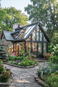 a house with lots of flowers and plants around it