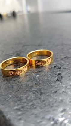 two gold wedding rings with the words divyo and stay together written on them