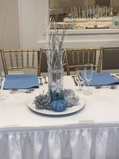 a table set with silver and blue decorations