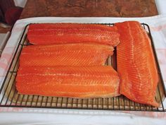 three raw salmons on a cooling rack ready to be cooked in the oven for consumption