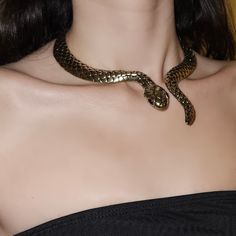 serpent, gold jewellery, gold necklace, snake jewellery, snake necklace, medusa, goddess aesthetic, dark feminine, dark feminine aesthetic, dark hair, pale skin, decolletage Gold Snake Accessories, Snake Charmer Aesthetic, Dark Feminine Accessories, Snake Outfit Aesthetic, Snake Necklace Gold, Snake Necklace Aesthetic, Dark Feminine Jewelry, Snake Jewelry Aesthetic, Cobra Aesthetic