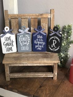 three wooden tags with the words home sweet home on them sitting on a bench next to a potted plant