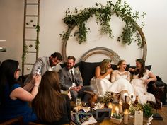 a group of people sitting around a table with food and drinks on it in front of them